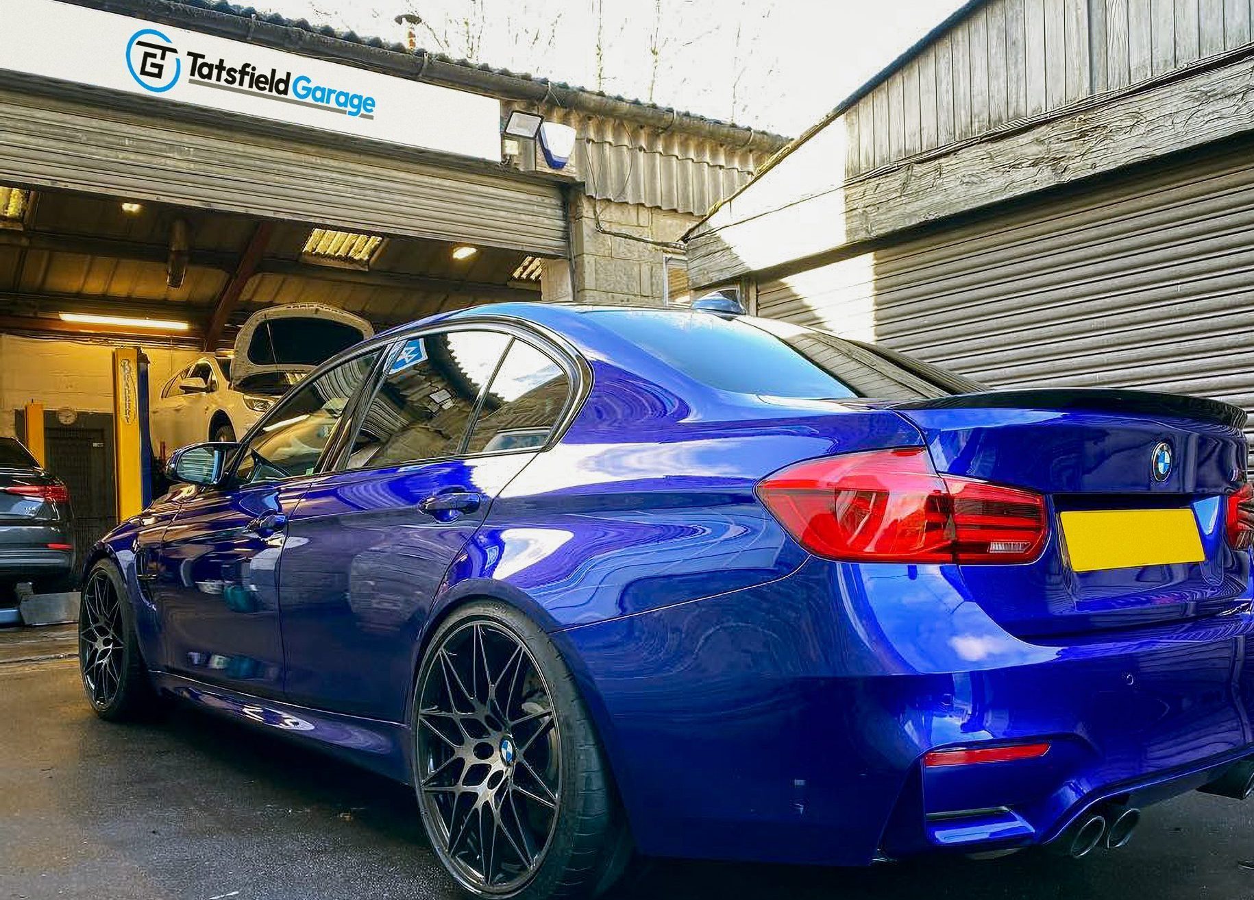 A blue BMW parked outside Tatsfield Garage